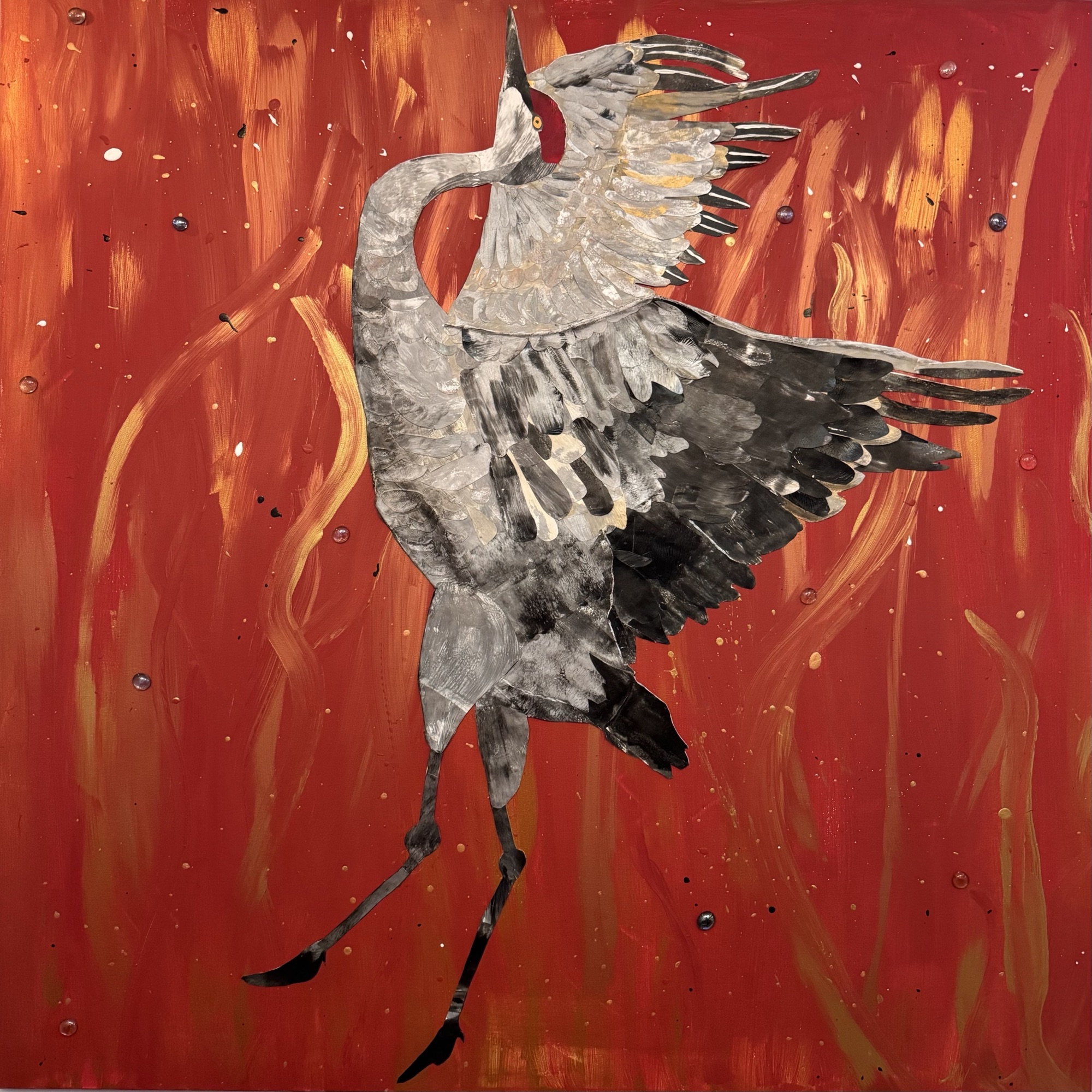 Freedom in the Fire — a sandhill crane dances with wings outstretched against a red and gold field of flames
